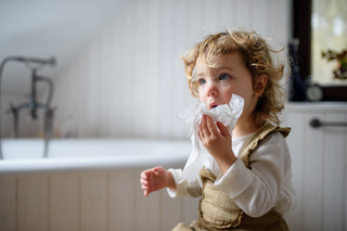 Sick child with enterovirus holding tissue