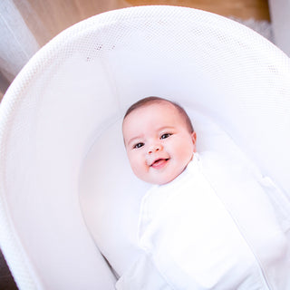 Happy baby swaddled in Ivory SNOO Sack in SNOO