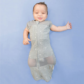 Baby in zipped-up graphite stars Sleepea swaddle sack with arms out