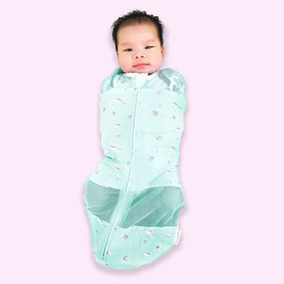 Baby in zipped-up teal planets Sleepea swaddle sack