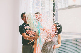 A family celebrates a gender reveal with pink confetti