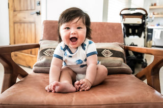 Happy baby sitting on chair, going through a growth spurt