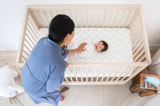 Mom touching baby who's on the DreamBreeZzz crib mattress