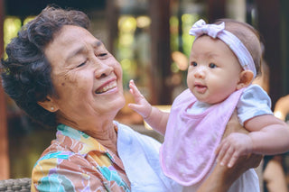 A grandmother holds her infant granddaughter