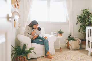 A mother holds her newborn baby in a stylish nursery