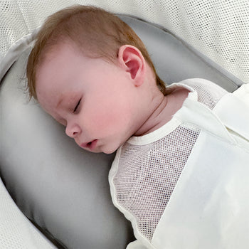 Baby sleeping peacefully on a gray silk SNOO Sheet in SNOO.