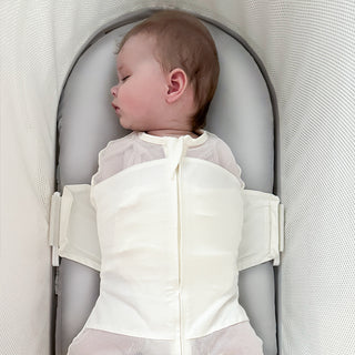 Baby swaddled sleeping on a gray silk SNOO Sheet in the SNOO bassinet.