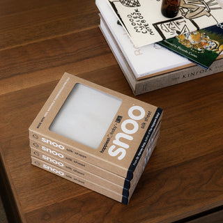 Stack of SNOO Silk Sheet boxes on a wooden dresser.