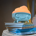 SNOObie white noise machine stacked on top of books glowing orange