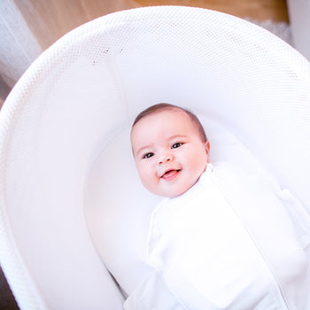 Happy baby swaddled in Ivory SNOO Sack in SNOO