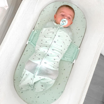 Baby sleeping in Teal Planets SNOO Sack on Teal Galaxy SNOO Sheet in SNOO 