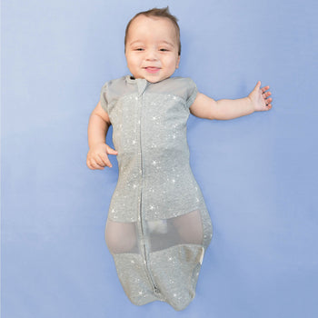 Baby in zipped-up graphite stars Sleepea swaddle sack with arms out